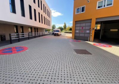 Marquage de pictogrammes "stationnement interdit" en thermoplastique sur du sol en klinkers