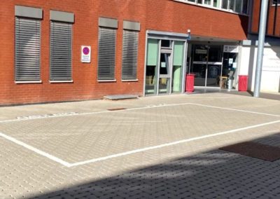 Emplacement de stationnement pour ambulance en thermoplastique sur sol en klinkers